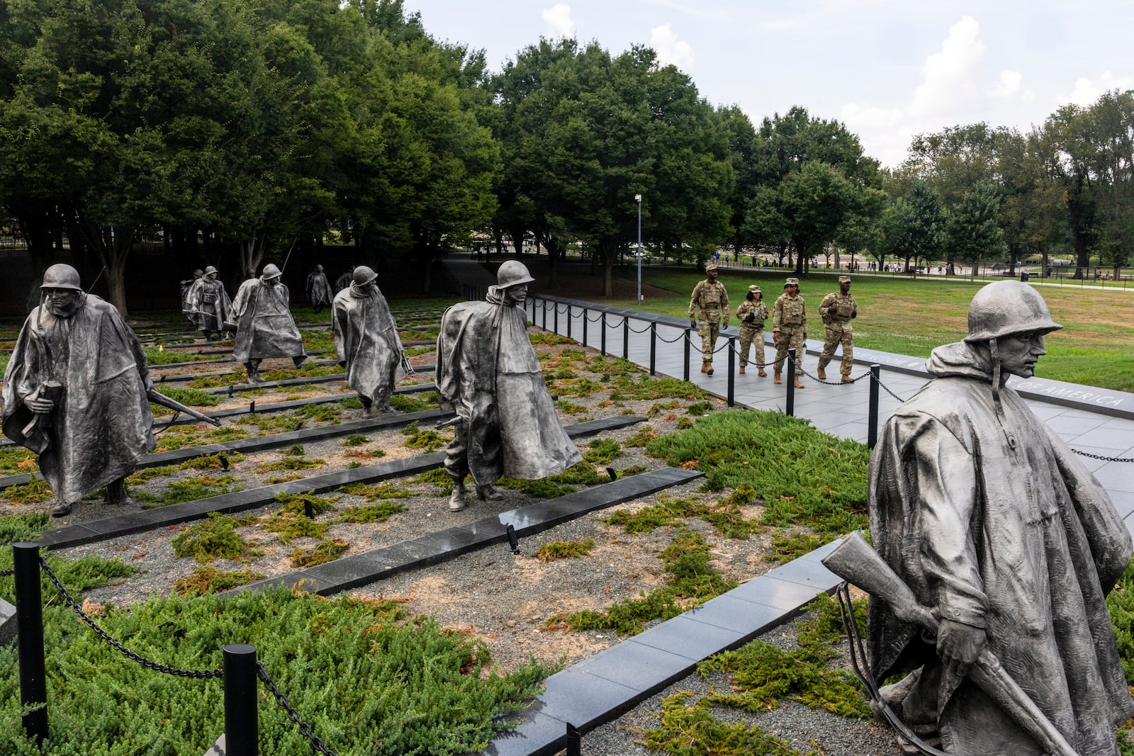 Members of the National Guard walk past the Korean War Veterans Memorial while patrolling on the National Mall in Washington, on Sunday, Aug. 17, 2025. (Alex Kent/The New York Times)