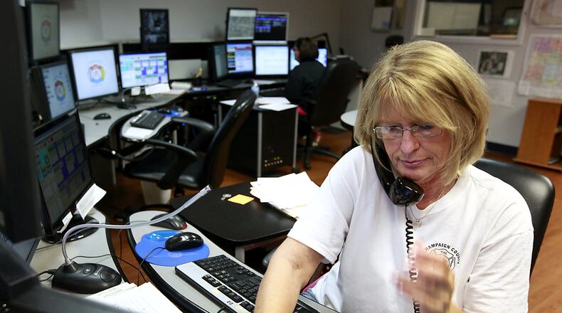 Linda Fleming, a dispatcher in the Champaign County 911 Dispatch Center, answers a call. Bill Lackey/Staff