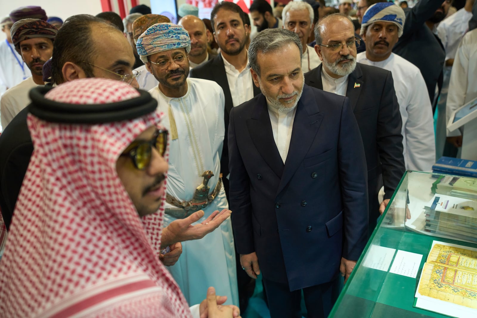 Iranian Foreign Minister Abbas Araghchi, center right, and Omani Foreign Minister Badr al-Busaidi, center left, walk through the Muscat International Book Fair in Oman, Friday, April 25, 2025. (AP Photo/Fatima Shbair)