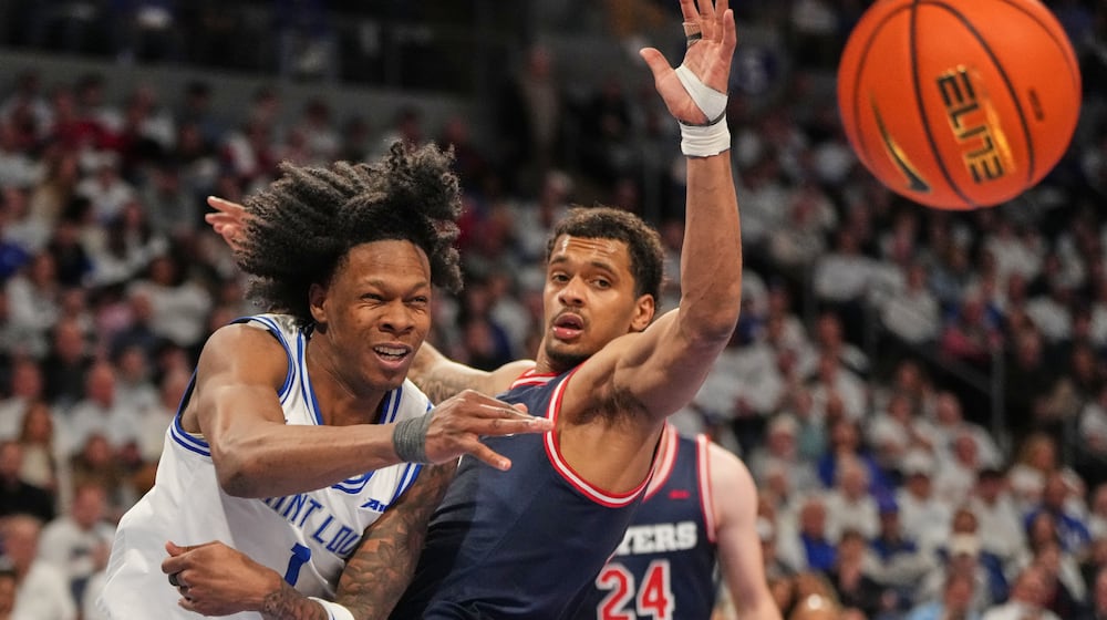 Saint Louis' Quentin Jones, left, ;passes as Dayton's De'shayne Montgomery, right, defends during the second half of an NCAA college basketball game Friday, Jan. 30, 2026, in St. Louis. (AP Photo/Jeff Roberson)