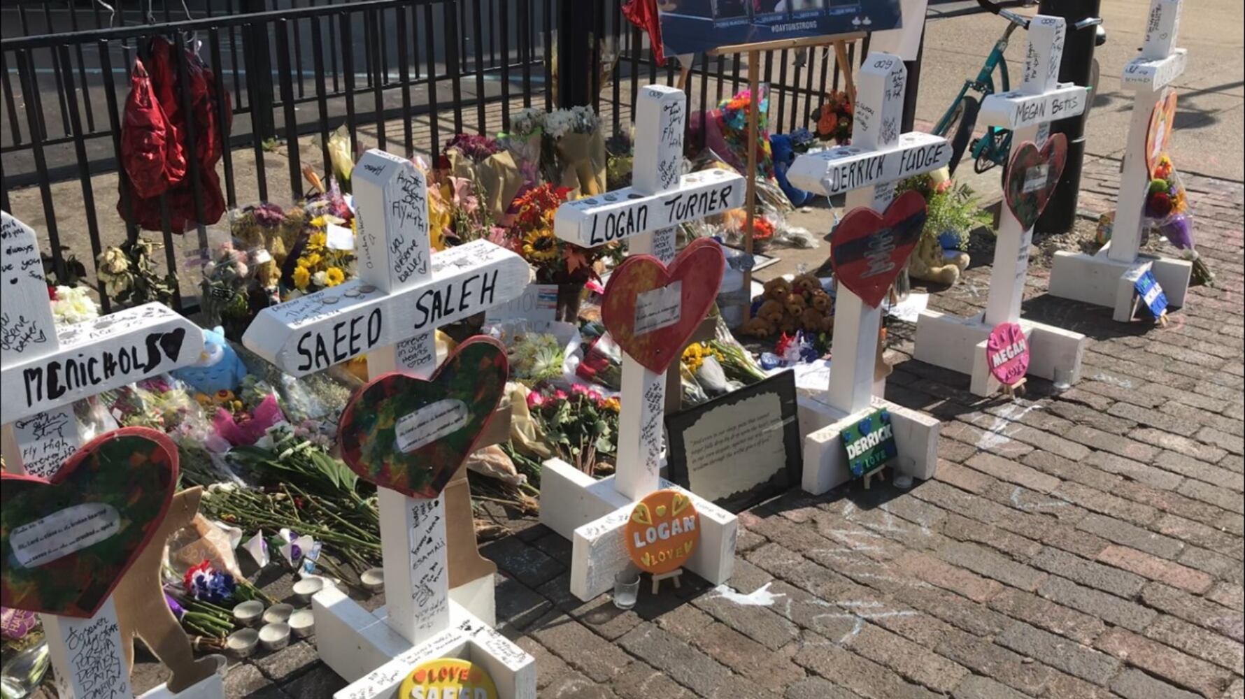 Photos of crosses lining the street in the Oregon District