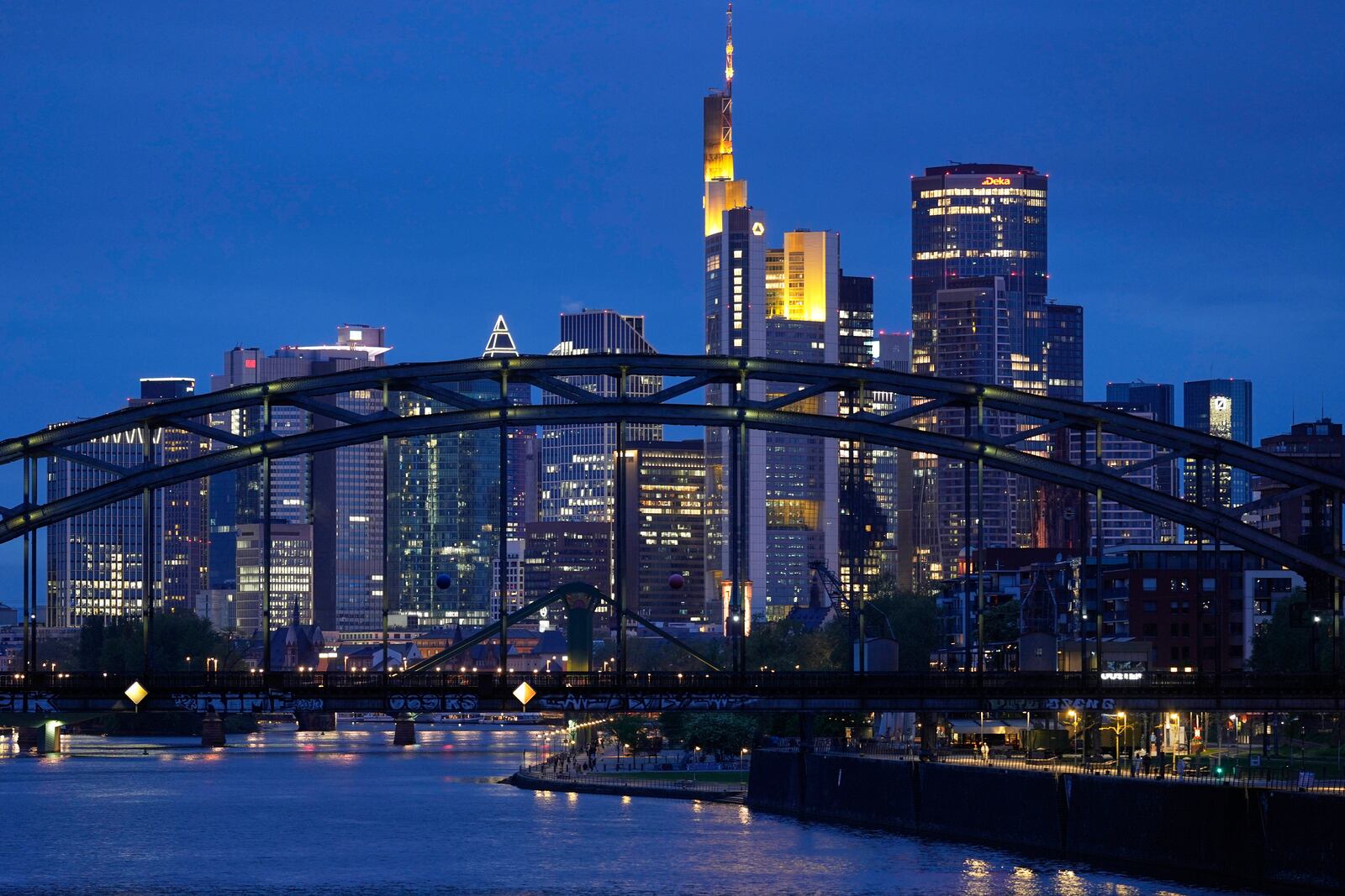 The lights of the buildings of the banking district are reflected in the river Main in Frankfurt, Germany, Wednesday, April 16, 2025. (AP Photo/Matthias Schrader)