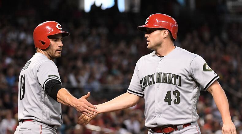 PHOENIX, AZ - MAY 28: Scott Schebler #43 of the Cincinnati Reds is congratulated by Joey Votto #19 after scoring against the Arizona Diamondbacks in the fifth inning of the MLB game at Chase Field on May 28, 2018 in Phoenix, Arizona. MLB players across the league are wearing special uniforms to commemorate Memorial Day. (Photo by Jennifer Stewart/Getty Images)