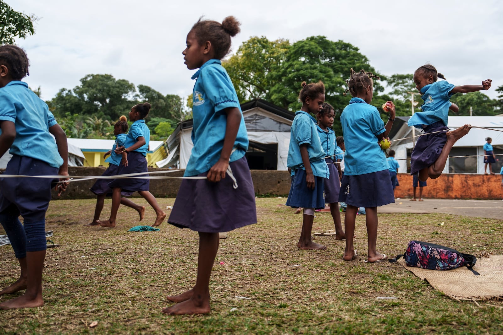 Students play outside tented classrooms at Sainte Jeanne D'Arc school in Port Vila, Vanuatu, Thursday, July 17, 2025. (AP Photo/Annika Hammerschlag)