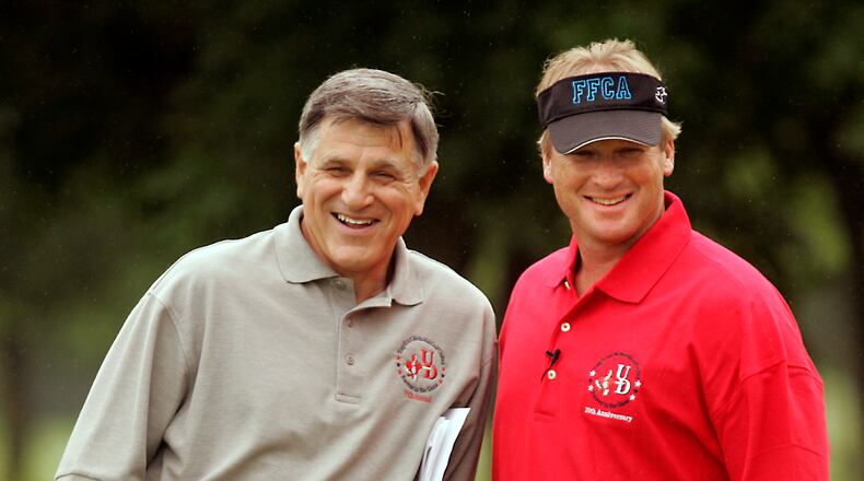 Former UD football coach Mike Kelly (L) and NFL TV analyst and former Super Bowl-winning coach Jon Gruden enjoy a light moment Friday on the course. Gruden provided celebrity to UD's annual golf outing, the Tony Ernst Memorial Golf Club at Yankee Trace Friday.Staff Photo by Jim Witmer