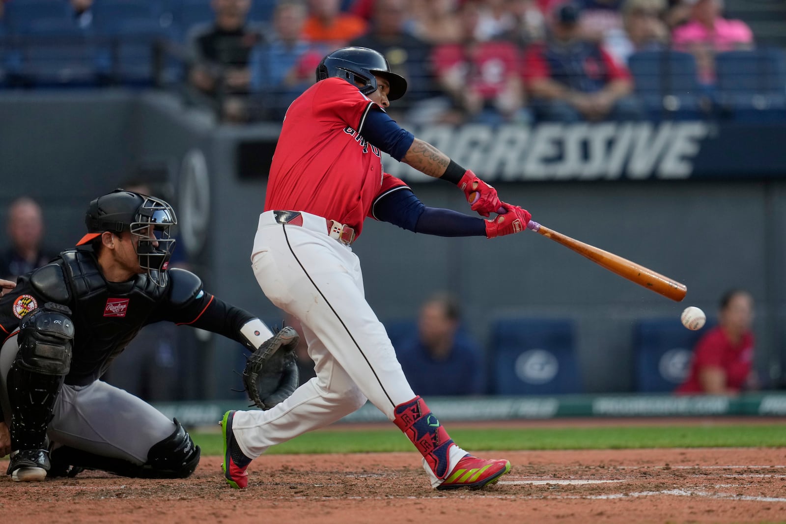 Cleveland Guardians' Jose Ramirez hits a single in front of Baltimore Orioles catcher Alex Jackson, left, in the fourthinning of a baseball game in Cleveland, Monday, July 21, 2025. (AP Photo/Sue Ogrocki)