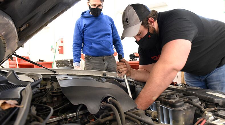 Retired Air Force Col. Curt Riedel (left) helps his son, Mark, replace the water pump in his Lincoln Town Car inside the Auto Hobby Shop at Wright-Patterson Air Force Base on Jan. 28. The Auto Hobby Shop supplies tools and lifts for do-it-yourself repairs and maintenance. It charges a nominal fee by appointment only. The shop is open to personnel who have access to Wright-Patterson Air Force Base. U.S. AIR FORCE PHOTO/TY GREENLEES