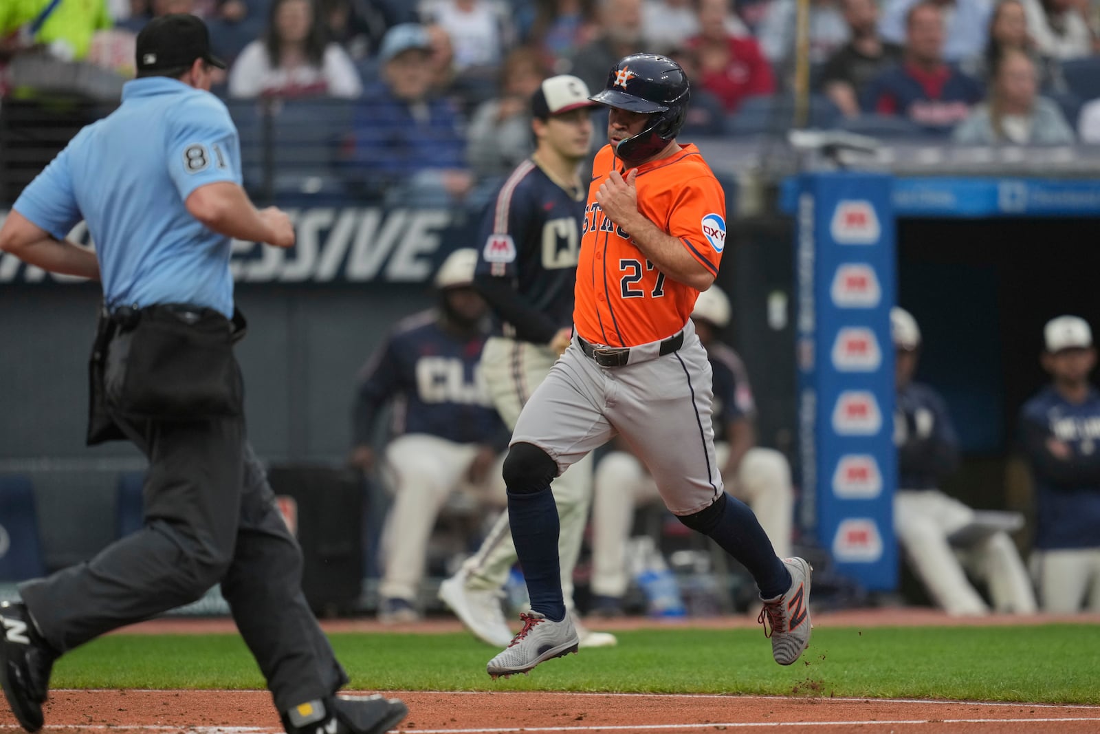 Houston Astros' Jose Altuve (27) scores in front of Cleveland Guardians starting pitcher Logan Allen, center, in the fifth inning of a baseball game in Cleveland, Friday, June 6, 2025. (AP Photo/Sue Ogrocki)