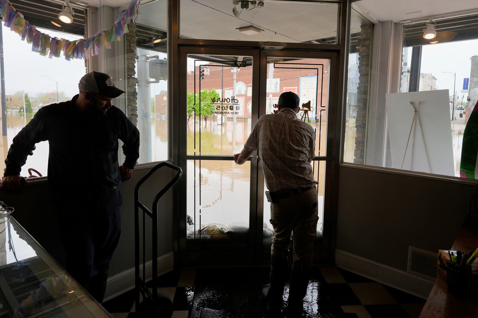 Brandon Sanderson, left, Josh Brashears set up sandbags after flooding in Hopkinsville, Ky., Friday, April 4, 2025. (AP Photo/George Walker IV)