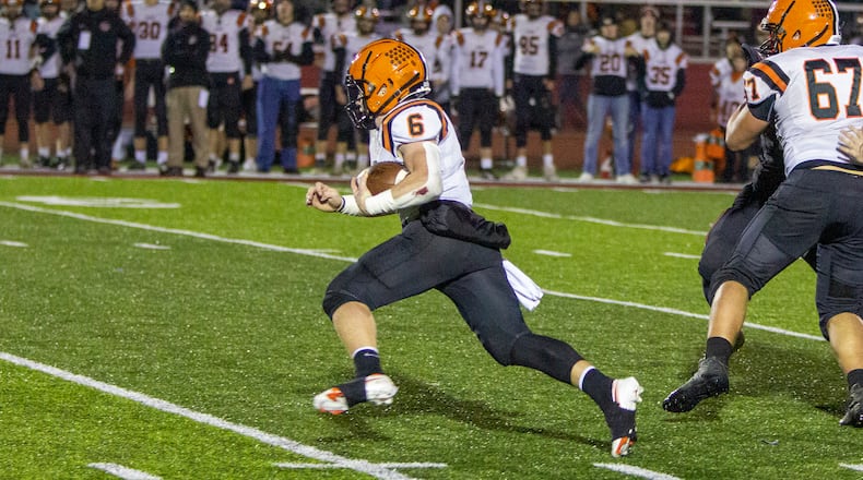 Versailles quarterback Carson Bey runs for a first down during the first half Saturday night against Preble Shawnee at Trotwood-Madison High School. Bey scored on the next play. jeff Gilbert/CONTRIBUTED