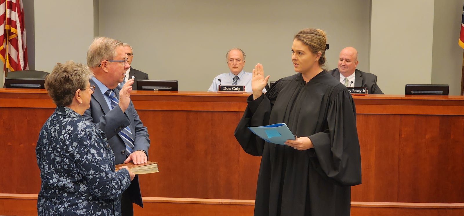 Judge Alyse Rettich (right) swears in Robert Matthews as Miami Twp.'s new fiscal officer beside his wife, Phyllis, at the start of a township Board of Trustees meeting Wednesday, April 3, 2024. Matthews earned 51.5% of the vote in November 2023, besting incumbent Greg Clingerman, who earned 48.5% of the vote. ERIC SCHWARTZBERG/STAFF