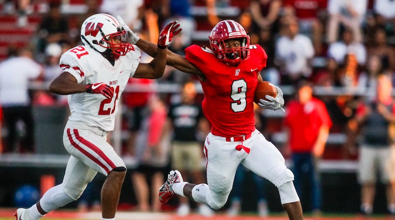 Fairfield's Jutahn McClain stiff arms Lakota West's Hunter Anderson II as he carries the football during their game Friday, Sept. 14 at Fairfield Stadium. Fairfield won 37-3. NICK GRAHAM/STAFF