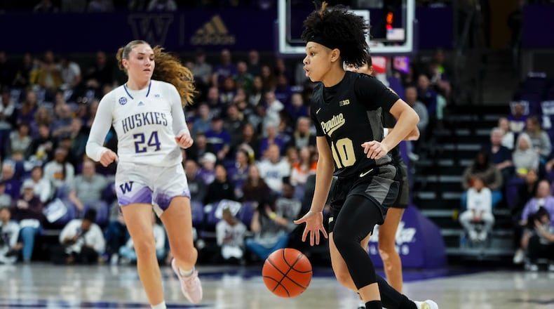 Purdue guard Jordyn Poole moves the ball against Washington guard Elle Ladine (24) during the first half of an NCAA college basketball game Saturday, Jan. 18, 2025, in Seattle. (AP Photo/Lindsey Wasson)