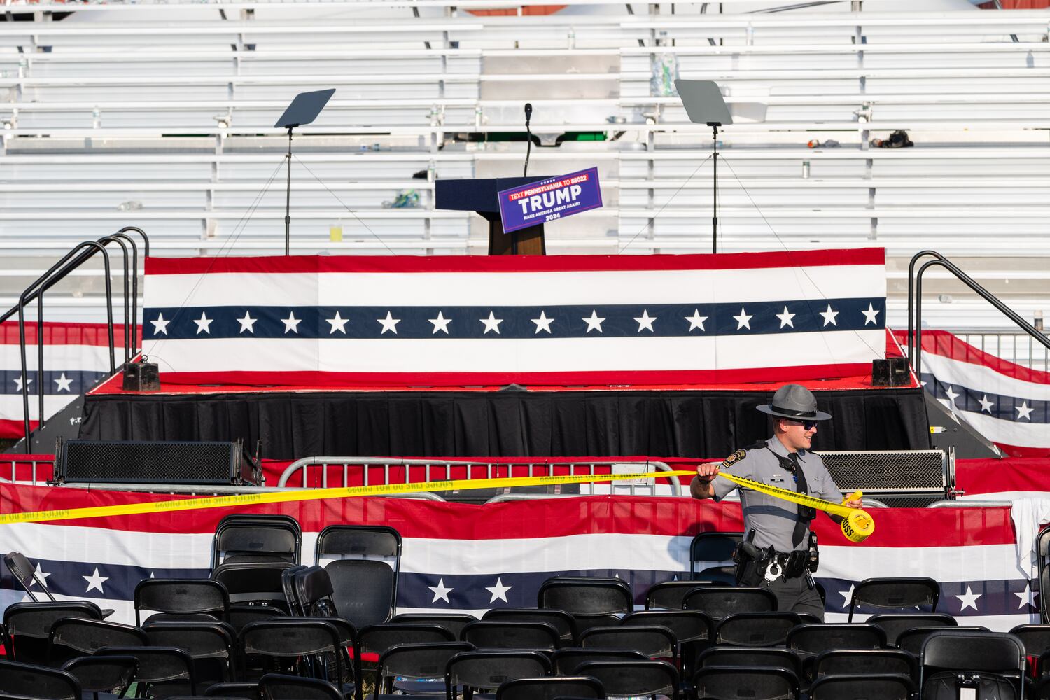 Police tape is stretched across the stage front after the attempted assassination of former President Donald Trump at a campaign rally in Butler, Pa., July, 13, 2024. (Eric Lee/The New York Times)