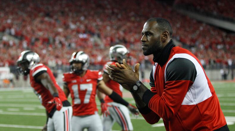 LeBron James cheers from the Ohio State sideline after a touchdown run by Ezekiel Elliott in the fourth quarter on Saturday, Sept. 6, 2014, at Ohio Stadium in Columbus. David Jablonski/Staff