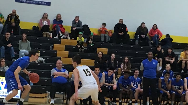 Cincinnati Christian coach Carl Woods (standing) watches CCS guard Brady Roberts (20) being covered by Georgetown’s Cameron Brookbank (15) on Saturday night during a Division IV sectional final at Taylor. RICK CASSANO/STAFF