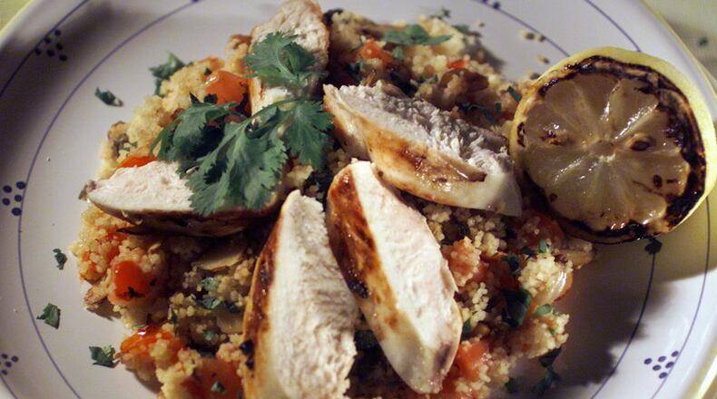 Chicken is marinated with lemon and garlic before grilling, then afterward is hit with more flavor from a grilled lemon. (Bob Chamberlin/Los Angeles Times/TNS)