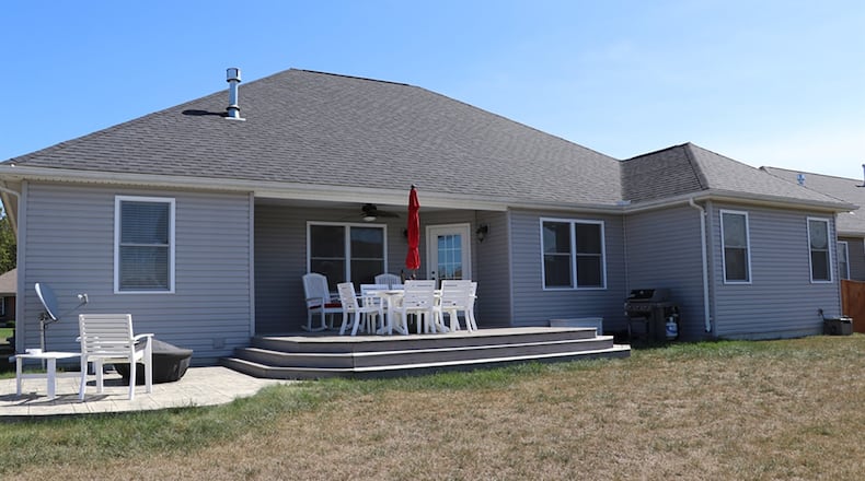 A door off the breakfast room opens to the covered porch with deck extension. There are two stamped-concrete patios.