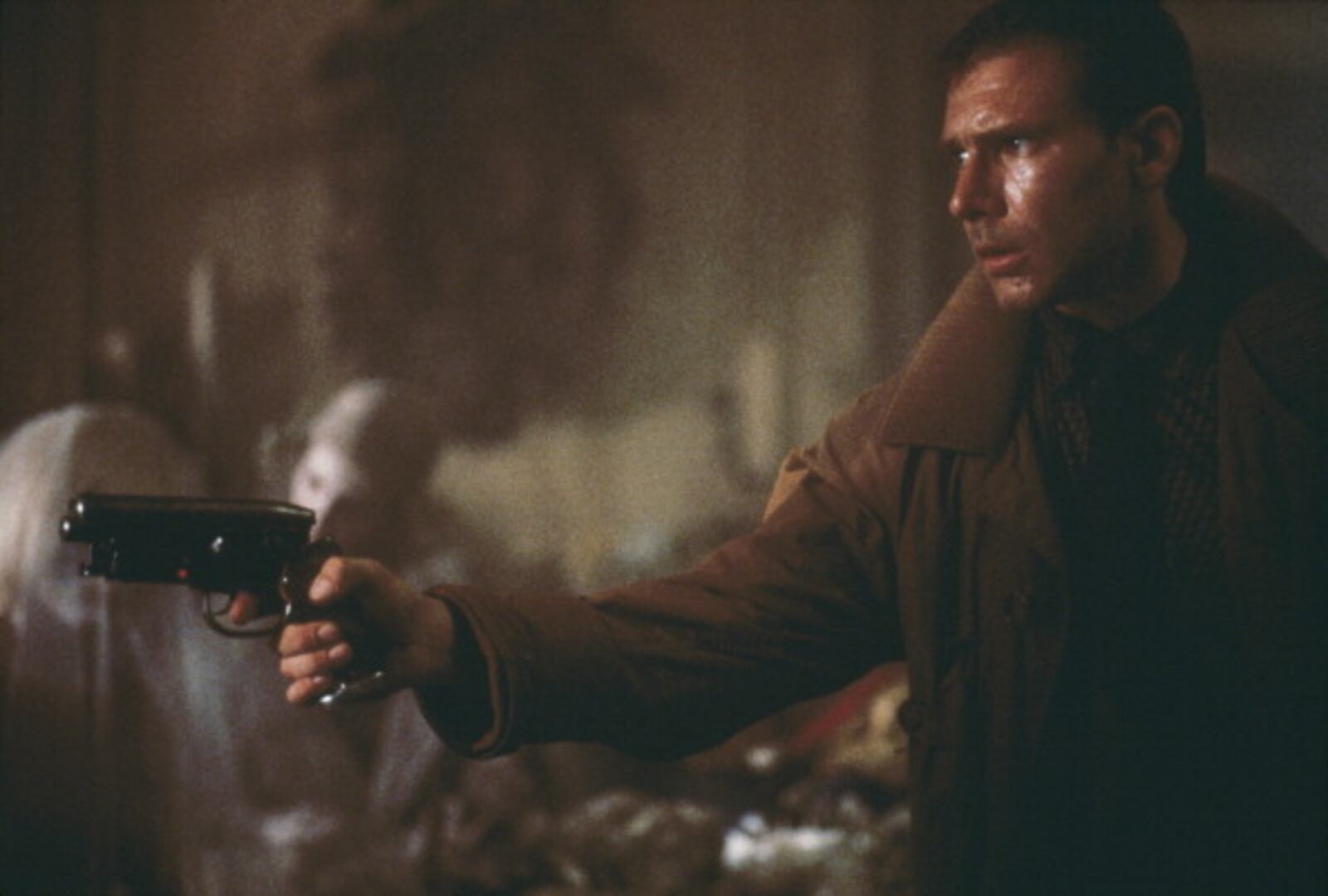 'Blade runner' Rick Deckard (Harrison Ford) enters Sebastian's apartment, where he is soon to be attacked by the replicant Pris (Daryl Hannah, immediately behind Deckard's gun), in a scene from Ridley Scott's futuristic thriller 'Blade Runner', 1982. (Photo by Warner Bros./Archive Photos/Getty Images)