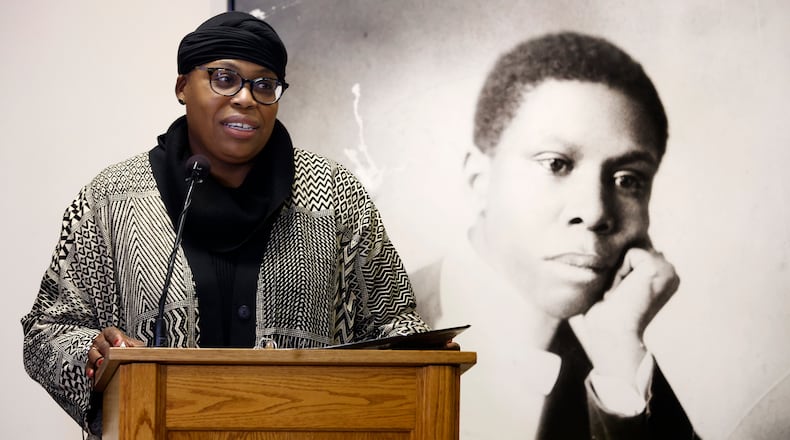 Sierra Leone, Dayton's first poet laureate, stands in front of a photo of Paul Laurence Dunbar Friday, Feb. 7, 2025 at a media event at the Paul Laurence Dunbar House Visitor Center. MARSHALL GORBY\STAFF