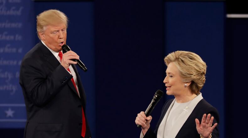 FILE - In this Sunday, Oct. 9, 2016, file photo, Republican presidential nominee Donald Trump and Democratic presidential nominee Hillary Clinton speak during the second presidential debate at Washington University in St. Louis. The contentiousness of the presidential election is spilling into some workplaces. And even when there’s no rancor, more time is spent on election chatter than in the past. Rather than try to control what people are saying, owners should focus on whether the work is getting done in an atmosphere that’s not hostile. (AP Photo/Patrick Semansky, File)