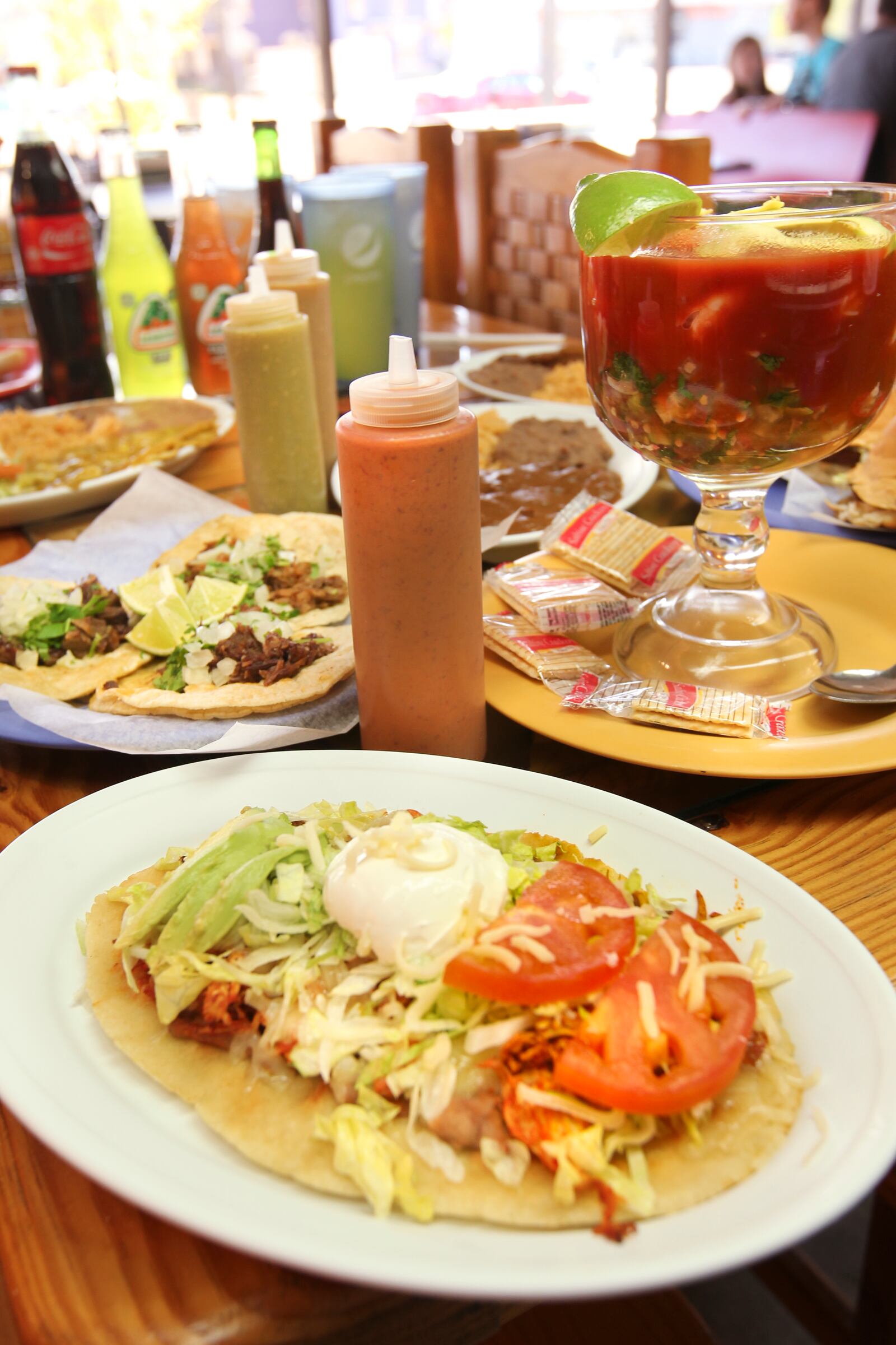 A spread of adventurous food at Taqueria Mixteca mexican restaurant at 1609 E. Third St., Dayton. Foreground shows Huarche, background left are three different meat tacos and on right in glass bowl is Seafood Cocktail.