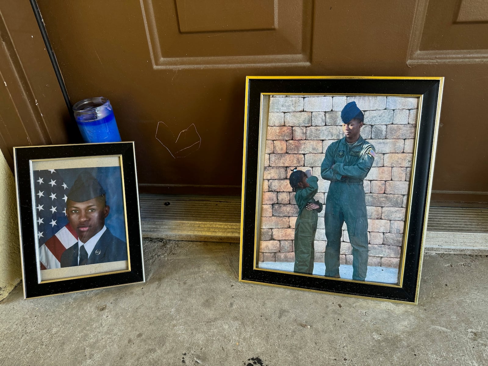 FILE - Candles and framed photos of Roger Fortson, a U.S. Air Force senior airman who was fatally shot by a Fla. sheriff's deputy on May 3, 2024, sit in the doorway of the apartment where he was killed in Fort Walton Beach, Fla., on Aug. 23. (AP Photo/Kate Payne, File)