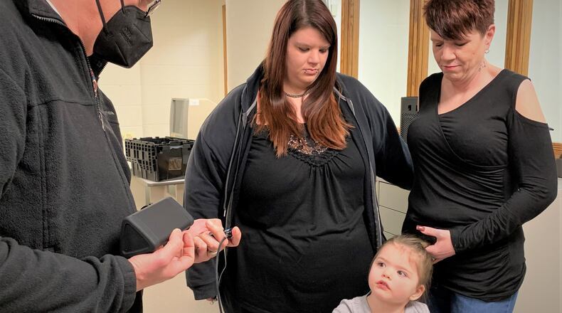 Three generations: Michele Arledge, her daughter Ashley Frauenknecht and granddaughter Nevaeh listen to a portion of Arledge's memoir played by Jonathan Platt of Story Chain.