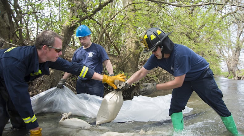 Responders with the 788th Civil Engineering Fire Department use sandbags and plastic to build a dam May 2 in Hebble Creek onWright-Patterson Air Force Base. The project was part of a base exercise used to train personnel in emergency response. (U.S. Air Force photos/R.J. Oriez)