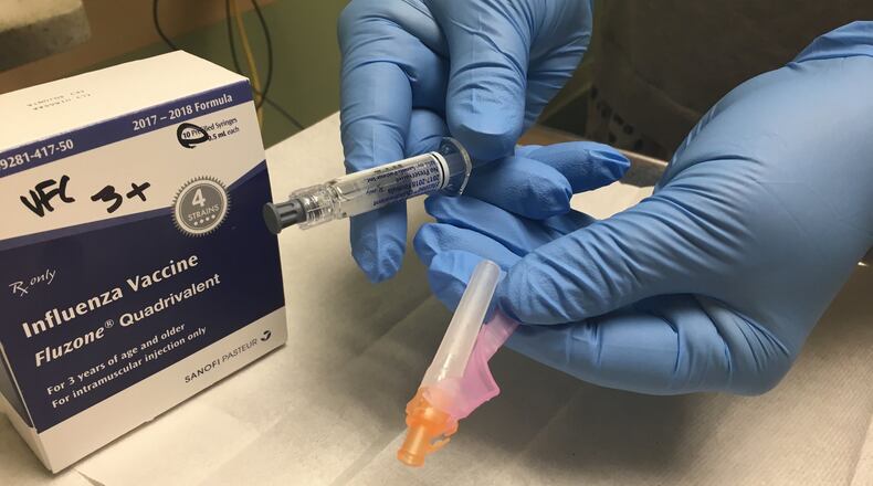 Lori Heins, immunization nurse with Public Health - Dayton & Montgomery County, holds a flu vaccine. KAITLIN SCHROEDER/STAFF