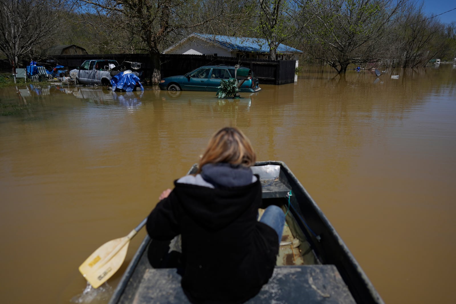Wanona Harp paddles through Lockport, Ky., flooded by the Kentucky River, Tuesday, April 8, 2025. (AP Photo/Carolyn Kaster)