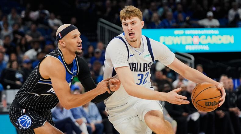 Dallas Mavericks forward Cooper Flagg (32) drives past Orlando Magic guard Jalen Suggs, left, during the first half of an NBA basketball game, Thursday, March 5, 2026, in Orlando, Fla. (AP Photo/John Raoux)