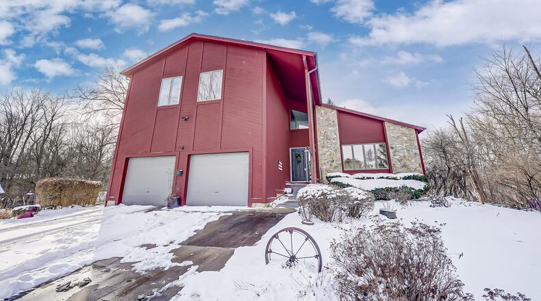 The front of this wood-and-stone home features a two-car attached garage and a two-story covered entry. Contributed photos