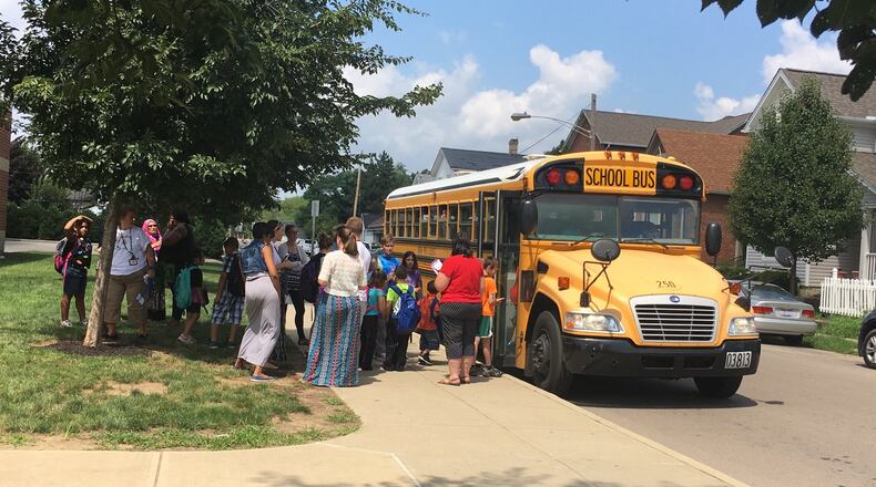 Students board a school bus outside Ruskin Elementary school in Dayton last fall as teachers and school staff monitor the area. JEREMY P. KELLEY / STAFF
