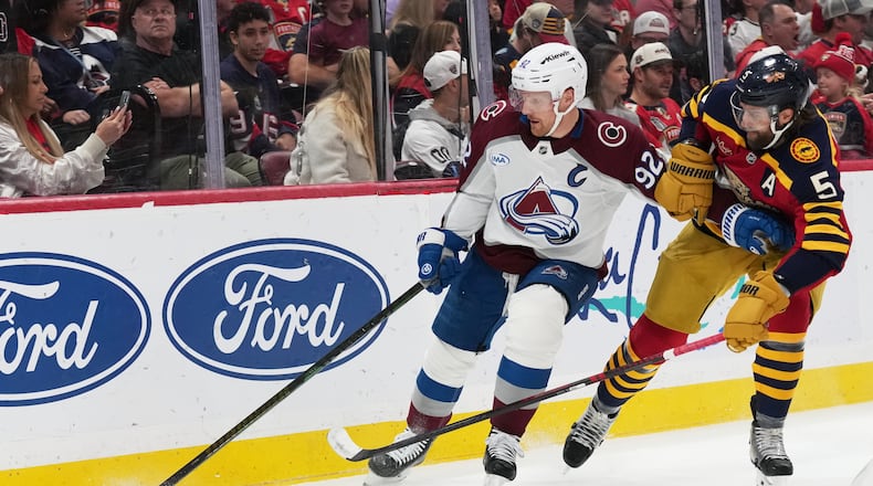 Colorado Avalanche left wing Gabriel Landeskog (92) skates with the puck as Florida Panthers defenseman Donovan Sebrango (6) defends during the first period of an NHL hockey game, Sunday, Jan. 4, 2026, in Sunrise, Fla. (AP Photo/Lynne Sladky)
