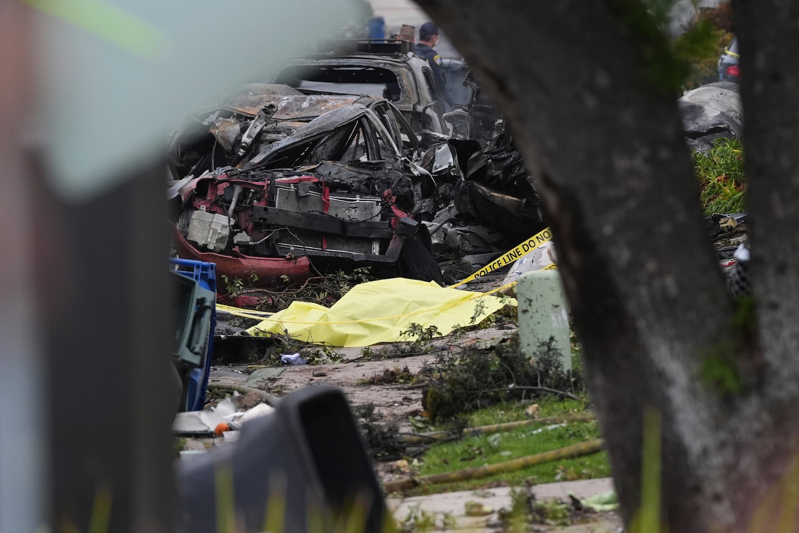 Authorities work the scene where a small plane crashed into a San Diego neighborhood, setting several homes on fire and forcing evacuations along several blocks early Thursday, May 22, 2025. (AP Photo/Gregory Bull)