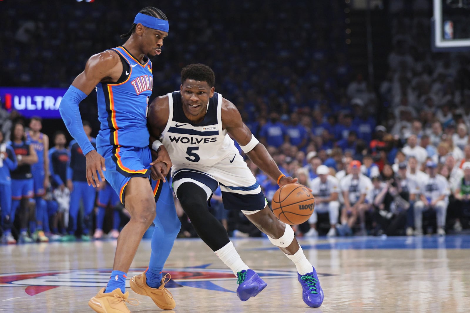Minnesota Timberwolves guard Anthony Edwards (5) works toward the basket as Oklahoma City Thunder guard Shai Gilgeous-Alexander (2) defends during the first half of Game 5 of the Western Conference finals of the NBA basketball playoffs, Wednesday, May 28, 2025, in Oklahoma City. (AP Photo/Nate Billings)