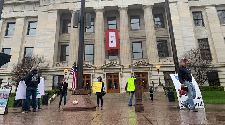 A small group of protesters assembled at the Ohio Statehouse just before the governor’s daily briefing on Friday. Laura Bischoff/Staff