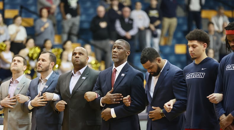 Dayton coach Anthony Grant, center, stands for the national anthem before a game against La Salle on Tuesday, Jan. 23, 2024, at Tom Gola Arena in Philadelphia. David Jablonski/Staff