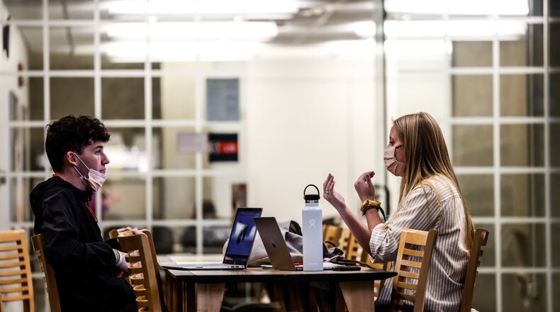 Sinclair College students Ryan Berner, left, and Mikala Coker talk in the school library.  Sinclair is one of the largest community colleges at a single location in the state of Ohio. JIM NOELKER/STAFF