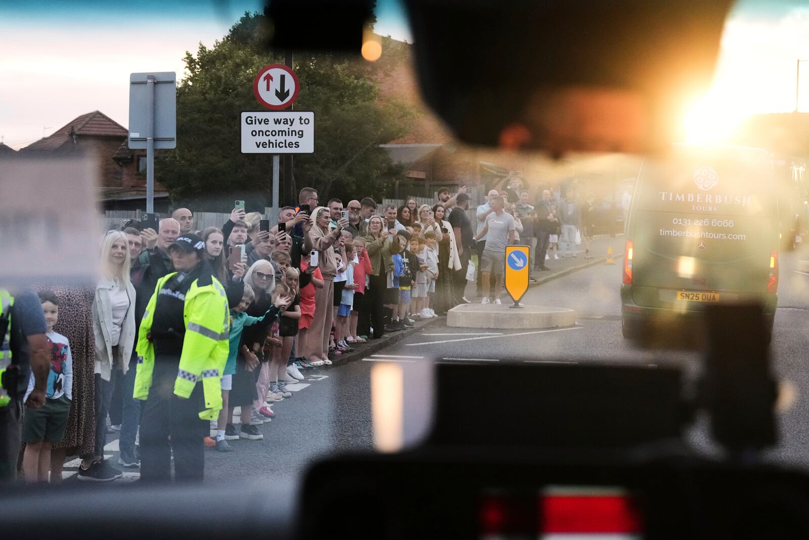 Onlookers take pictures as the convoy with President Donald Trump passes by in Turnberry, Scotland, Friday, July 25, 2025.(AP Photo/Jacquelyn Martin)