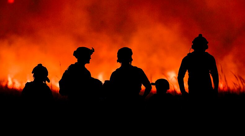FILE — U.S. Special Operations Service members are illuminated by the glow of orange flames from a brush fire caused by the continued firing of shoulder-fired rocket launchers at a remote range in Fort Chaffee, Ark., on Oct. 23, 2023. Troops whose jobs can expose them repeatedly to blasts from their own weapons have among the highest suicide rates in the armed forces, according to a new report by the Defense Department. (Kenny Holston/The New York Times)