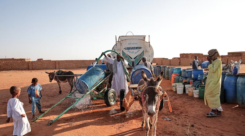 FILE - People fill water containers at a free distribution point due to water outages in Khartoum, Sudan, on Jan. 30, 2026. (AP Photo/Marwan Ali, File)