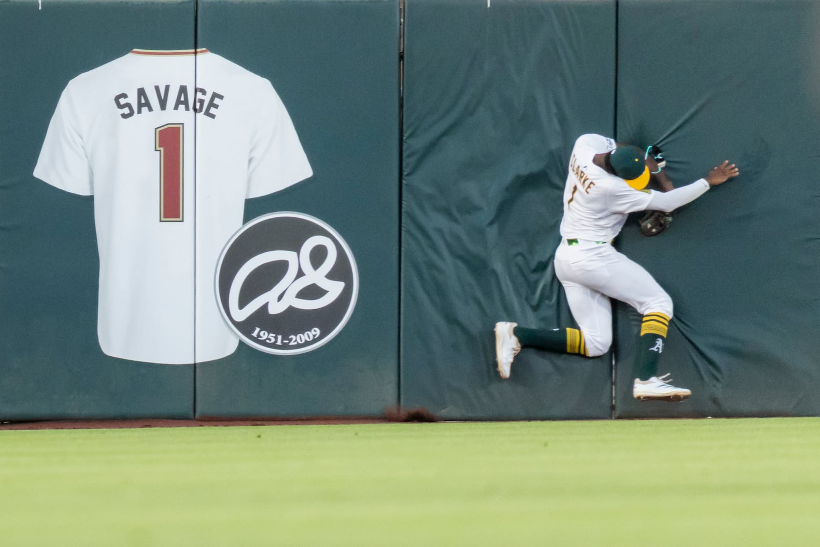 Athletics outfielder Denzel Clarke collides into the wall after making the catch during the fourth inning of a baseball game against the Baltimore Orioles Friday, June 6, 2025, in West Sacramento, Calif. (AP Photo/Sara Nevis)