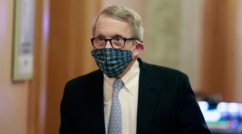 Ohio Gov. Mike DeWine walks into his daily coronavirus news conference at the Ohio Statehouse in Columbus, wearing a mask made by his wife, first lady Fran DeWine. (Doral Chenoweth/The Columbus Dispatch via AP, File)