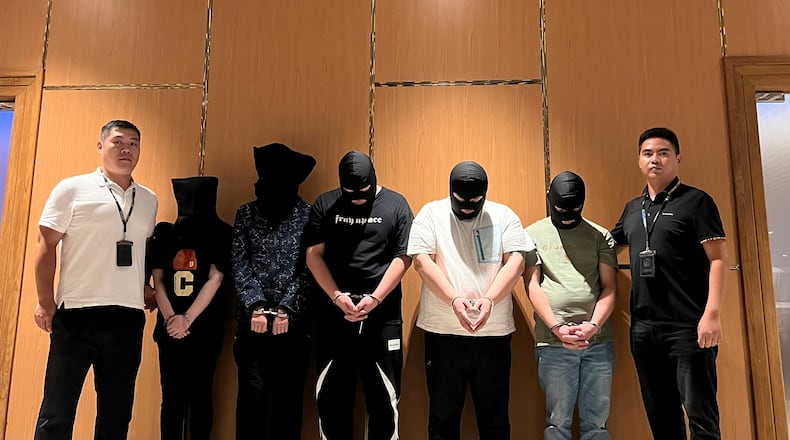 FILE - In this photo released by Xinhua News Agency, Myanmar police hand over five telecom and internet fraud suspects to Chinese police at Yangon International Airport in Yangon, Myanmar, Aug. 26, 2023. (Chinese embassy in Myanmar/Xinhua via AP)