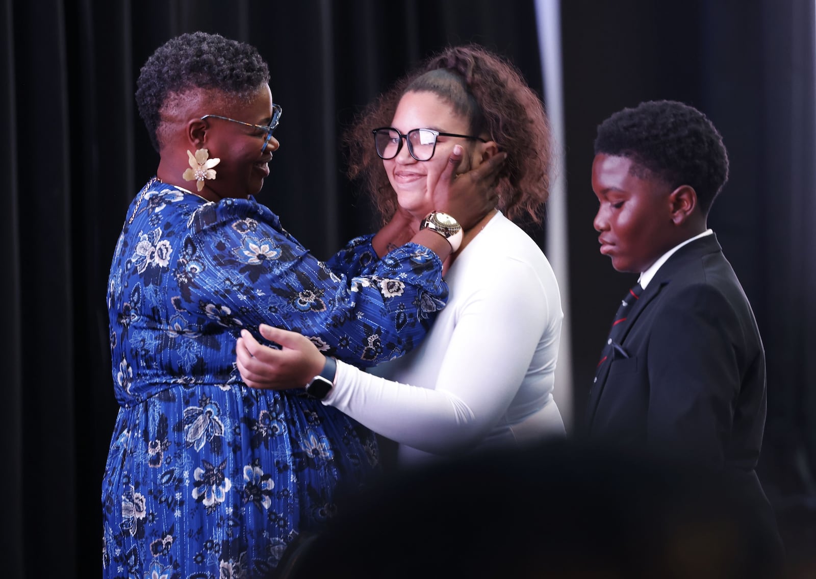 Crystal Allen, CEO and President of The Boys & Girls Club of Dayton, left, hugs Youth of the Year, Ke'mya Lam, 18, with her brother, Keonti Rutledge, by her side during their fifth annual Spark Great Futures fundraiser Thursday, Oct. 23, 2025 at Dayton Arcade. The signature event, sponsored by CareSource, celebrates the power of mentorship, leadership, and community while shining a spotlight on the transformational impact of the Boys & Girls Club of Dayton. WNBA Stars Kelsey Mitchell and Sophie Cunningham were special guests for the event. NICK GRAHAM/STAFF