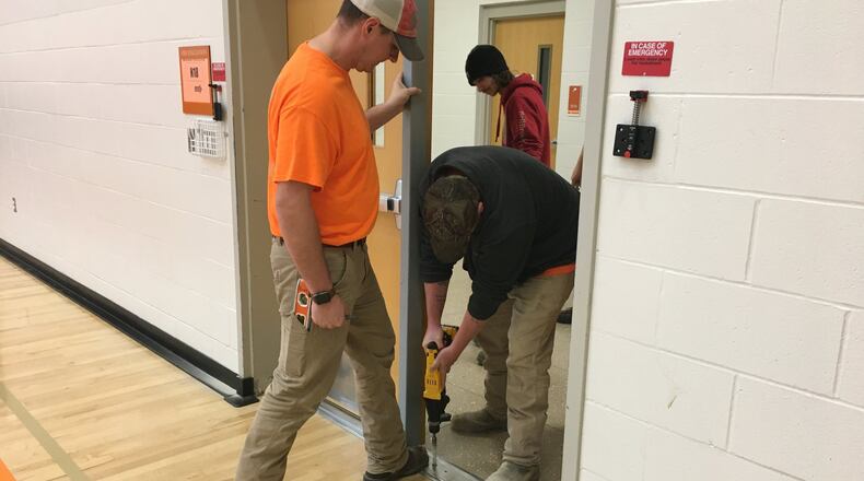 Workers with Bellbrook Fence Company volunteered their time to install Anchorman locks on 100 doors inside the Jacob Coy Middle School in Beavercreek Wednesday Nov. 27, 2019. RICHARD WILSON/STAFF