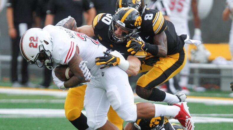 IOWA CITY, IOWA- SEPTEMBER 01: Defensive backs Jake Gervase #30, Matt Hankins #8 and Amani Hooker #27 of the Iowa Hawkeyes combine during the first half to tackle tailback Tre Harbison #22 of the Northern Illinois Huskies on September 1, 2018 at Kinnick Stadium, in Iowa City, Iowa. (Photo by Matthew Holst/Getty Images)