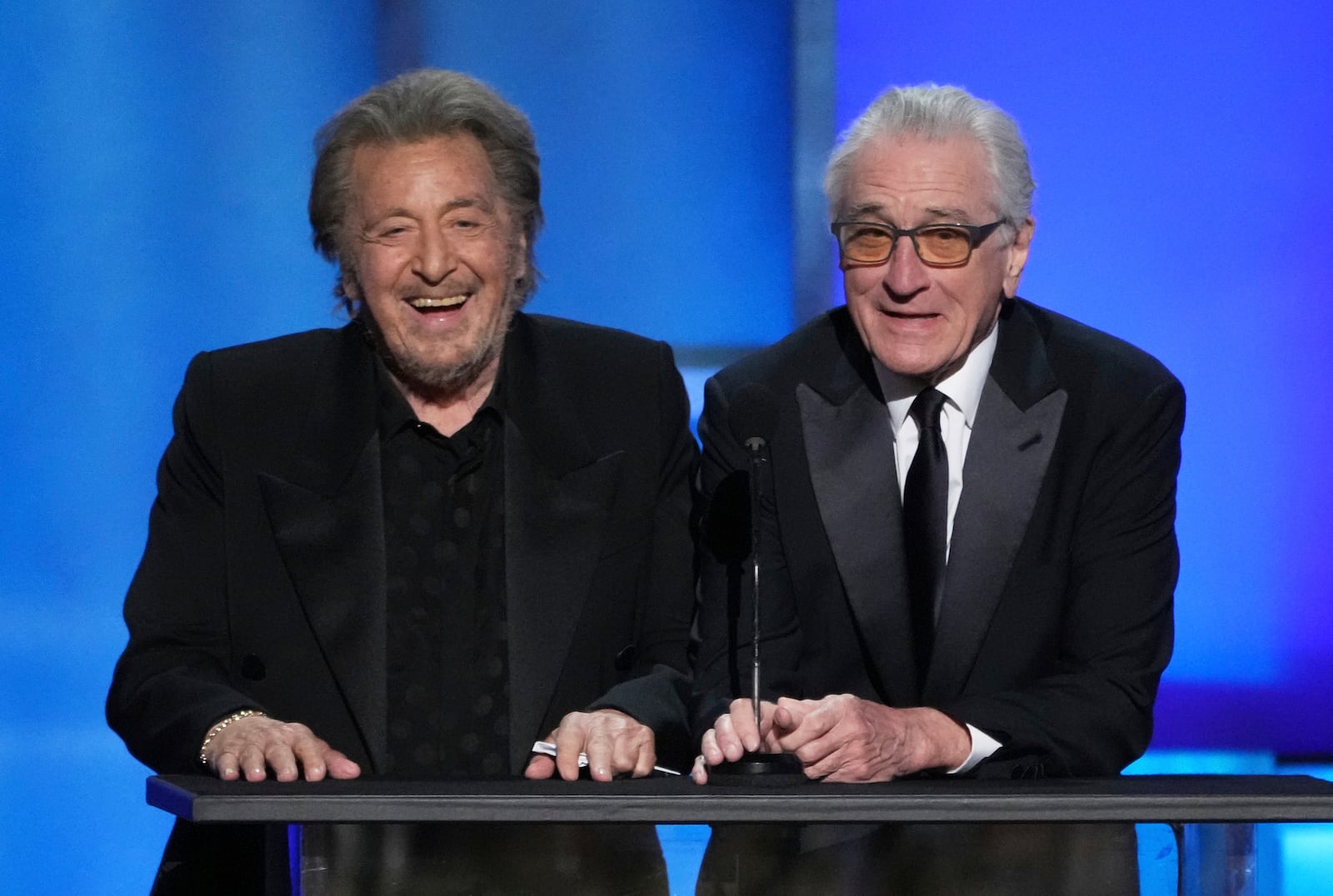 Actors Al Pacino, left, and Robert De Niro share a laugh onstage during the 50th AFI Life Achievement Award tribute to Francis Ford Coppola on Saturday, April 26, 2025, at the Dolby Theatre in Los Angeles. (AP Photo/Chris Pizzello)
